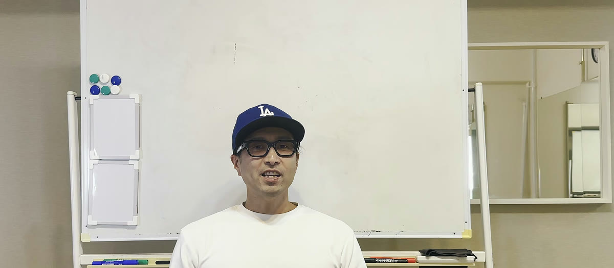 ホワイトボードの前で講義する増田
